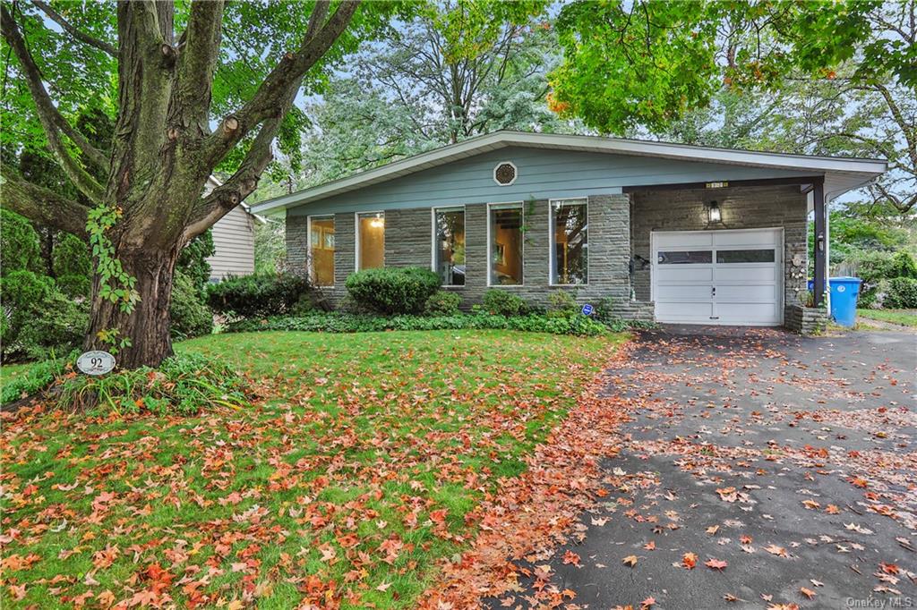 View of front of house featuring a garage and a front yard