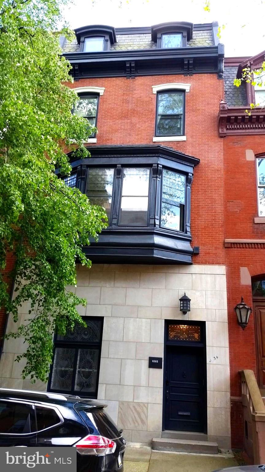 a front view of a house with plants