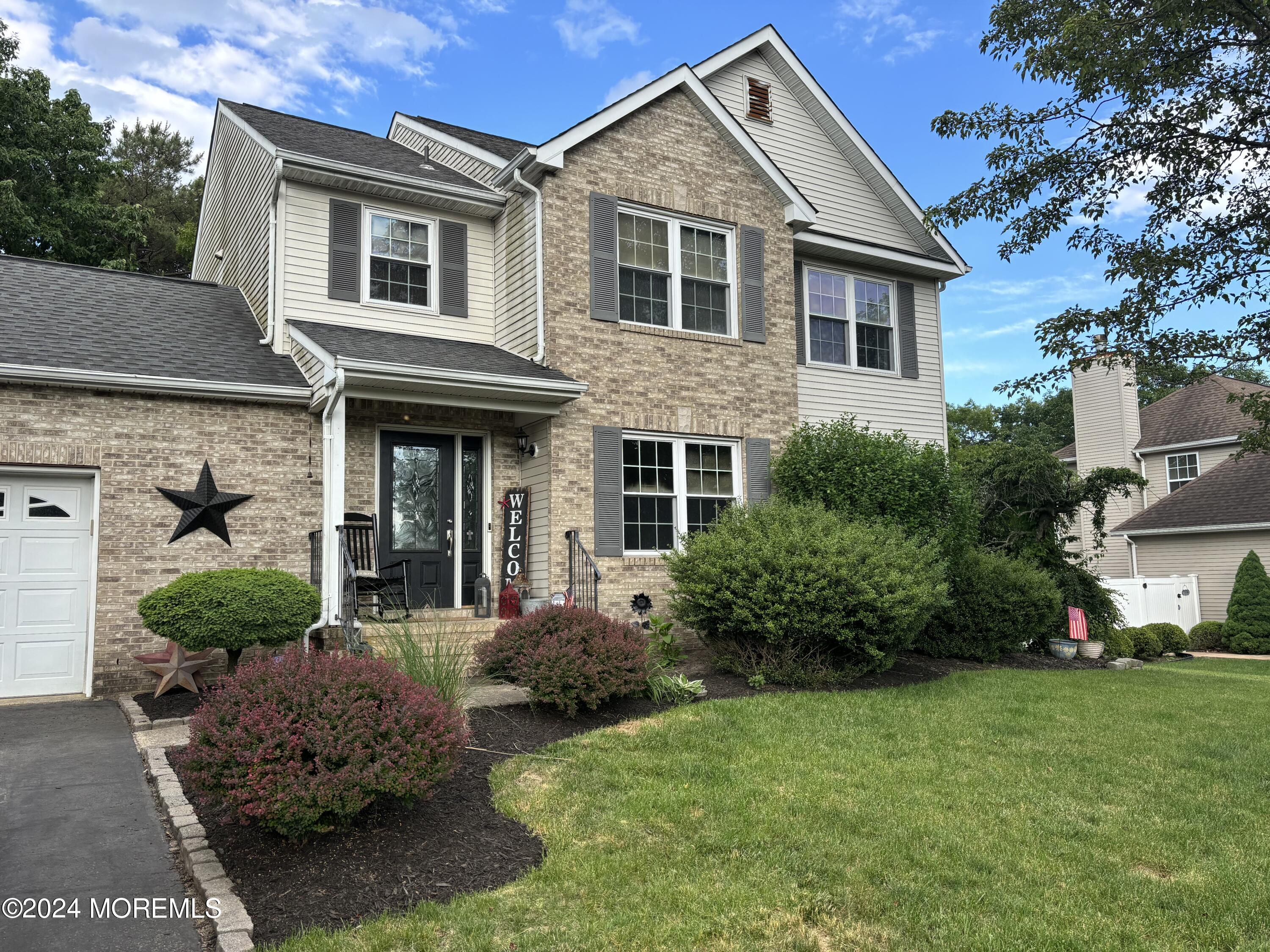 a front view of a house with a yard and potted plants