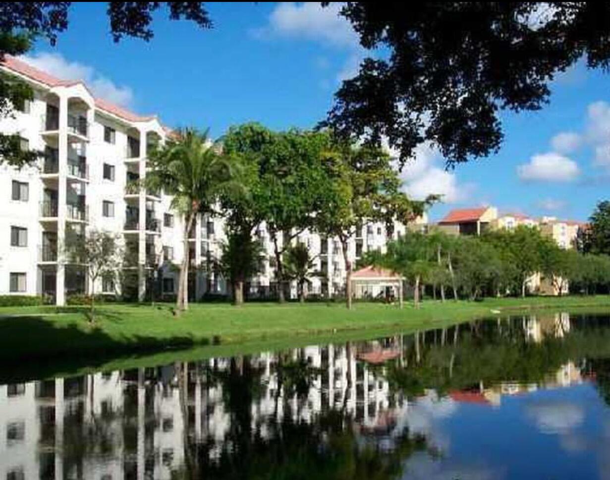 a view of a lake with a big yard and large trees