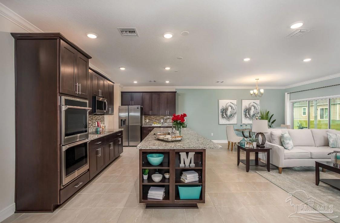 a kitchen with stainless steel appliances granite countertop a refrigerator and a stove top oven