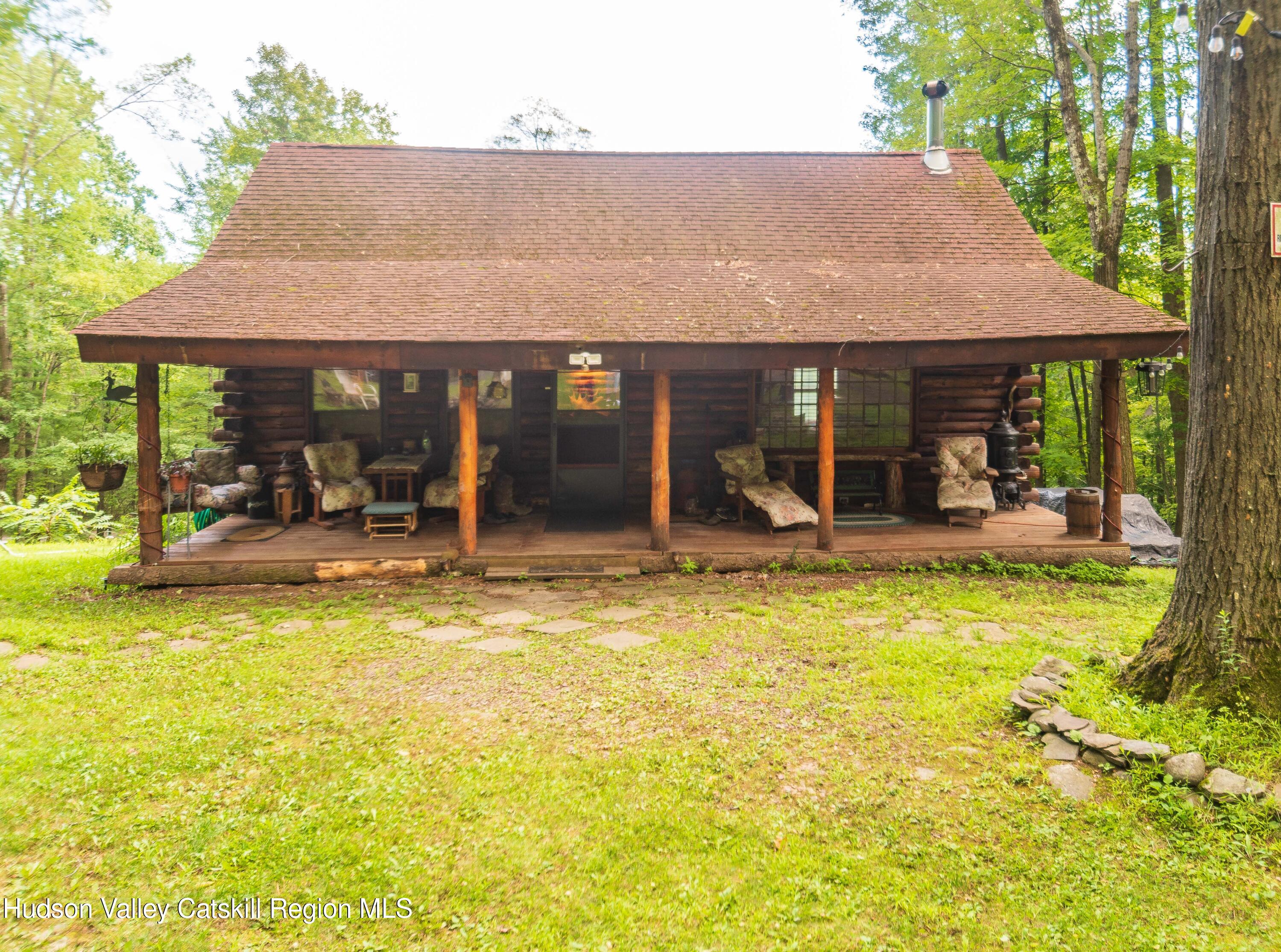 a view of a house with floor to ceiling windows and a lawn chair