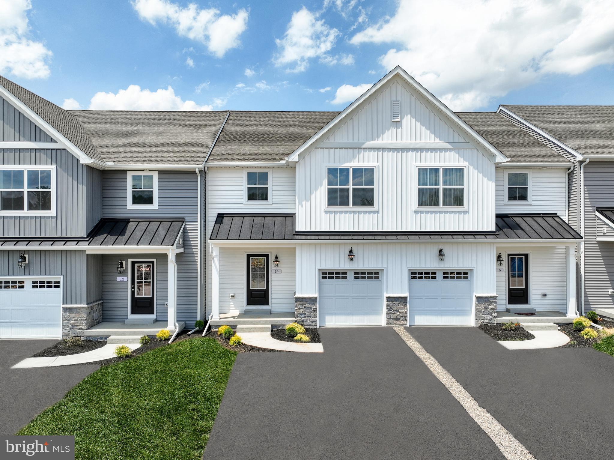 a front view of a house with yard and parking