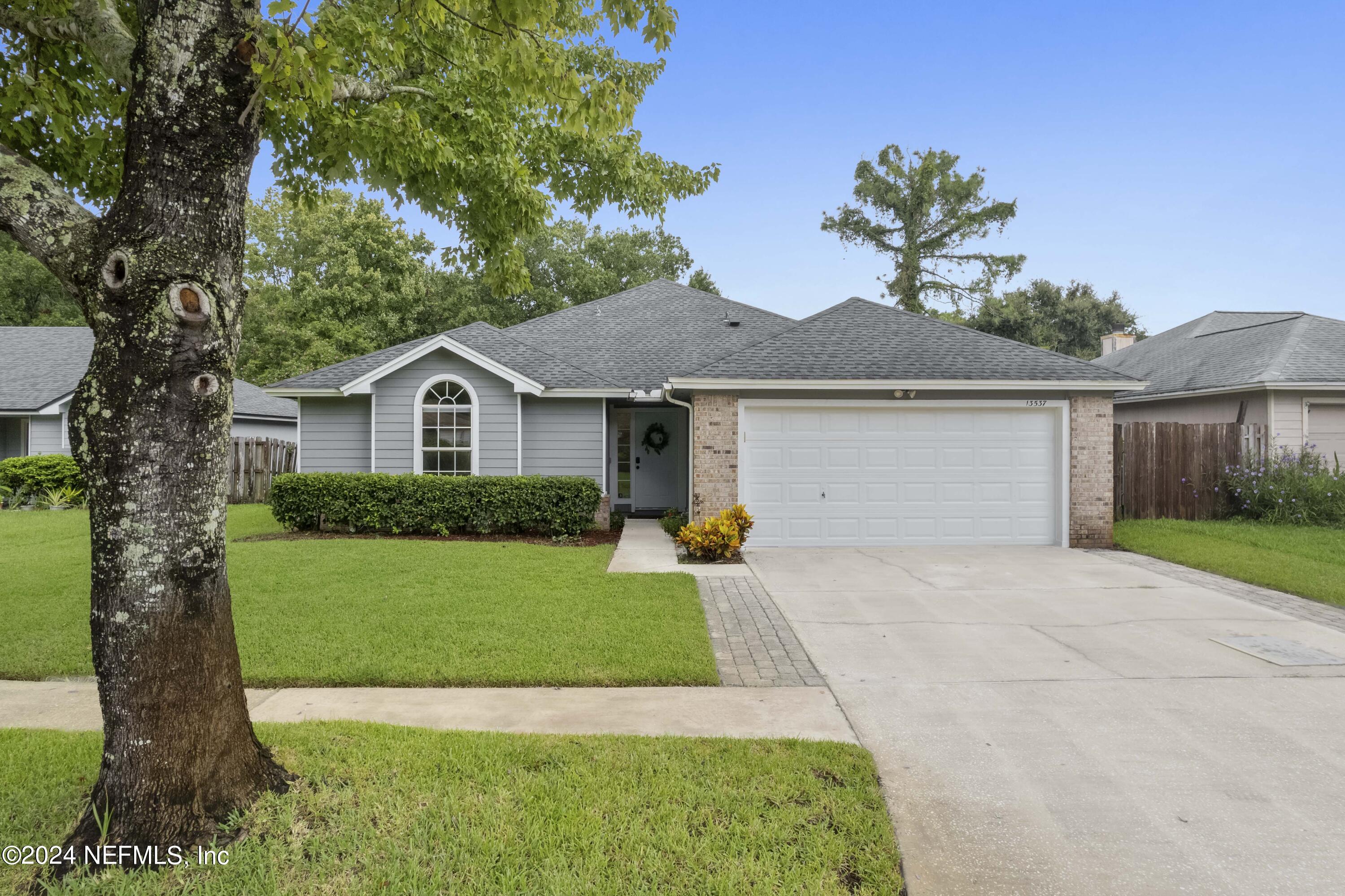 a front view of a house with a yard and garage