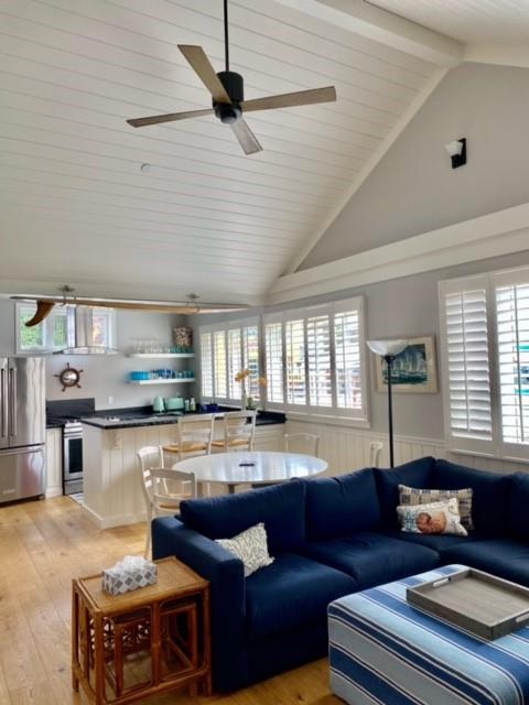 a living room with stainless steel appliances kitchen island granite countertop furniture and a large window