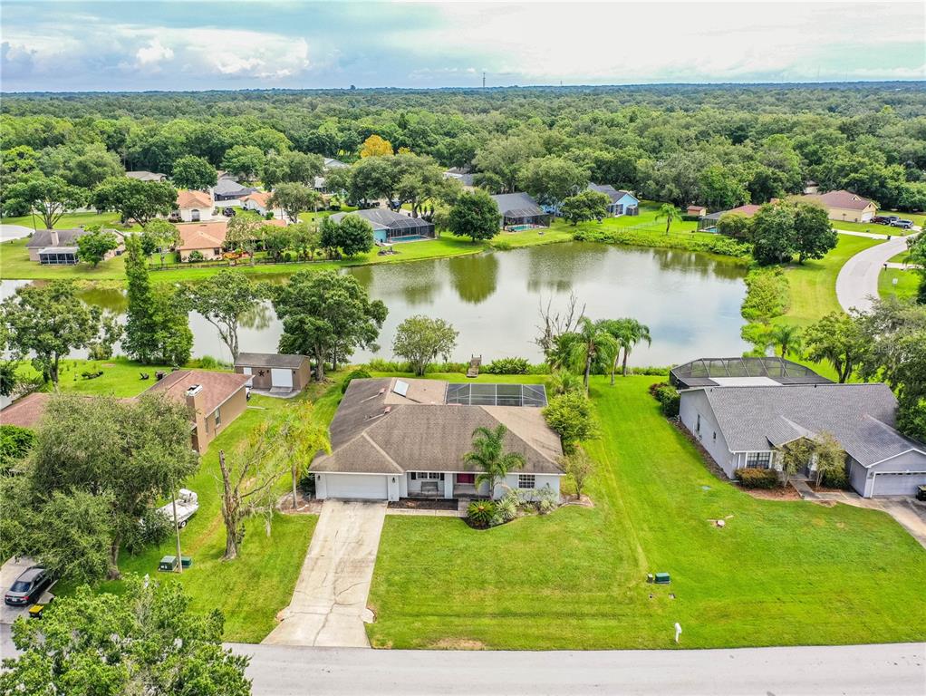 an aerial view of a residential houses with outdoor space and lake view