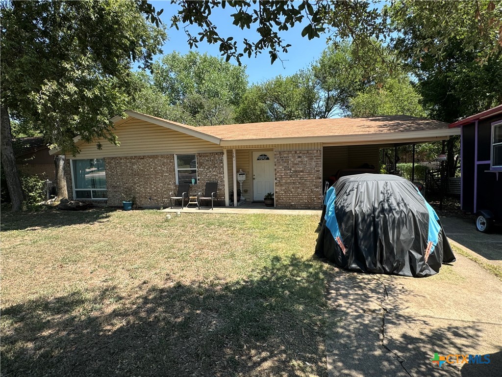 a view of a house with a yard and large tree