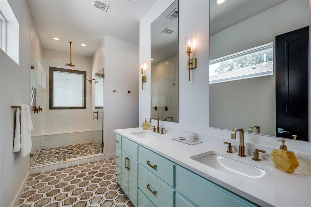 a bathroom with a double vanity sink mirror and shower