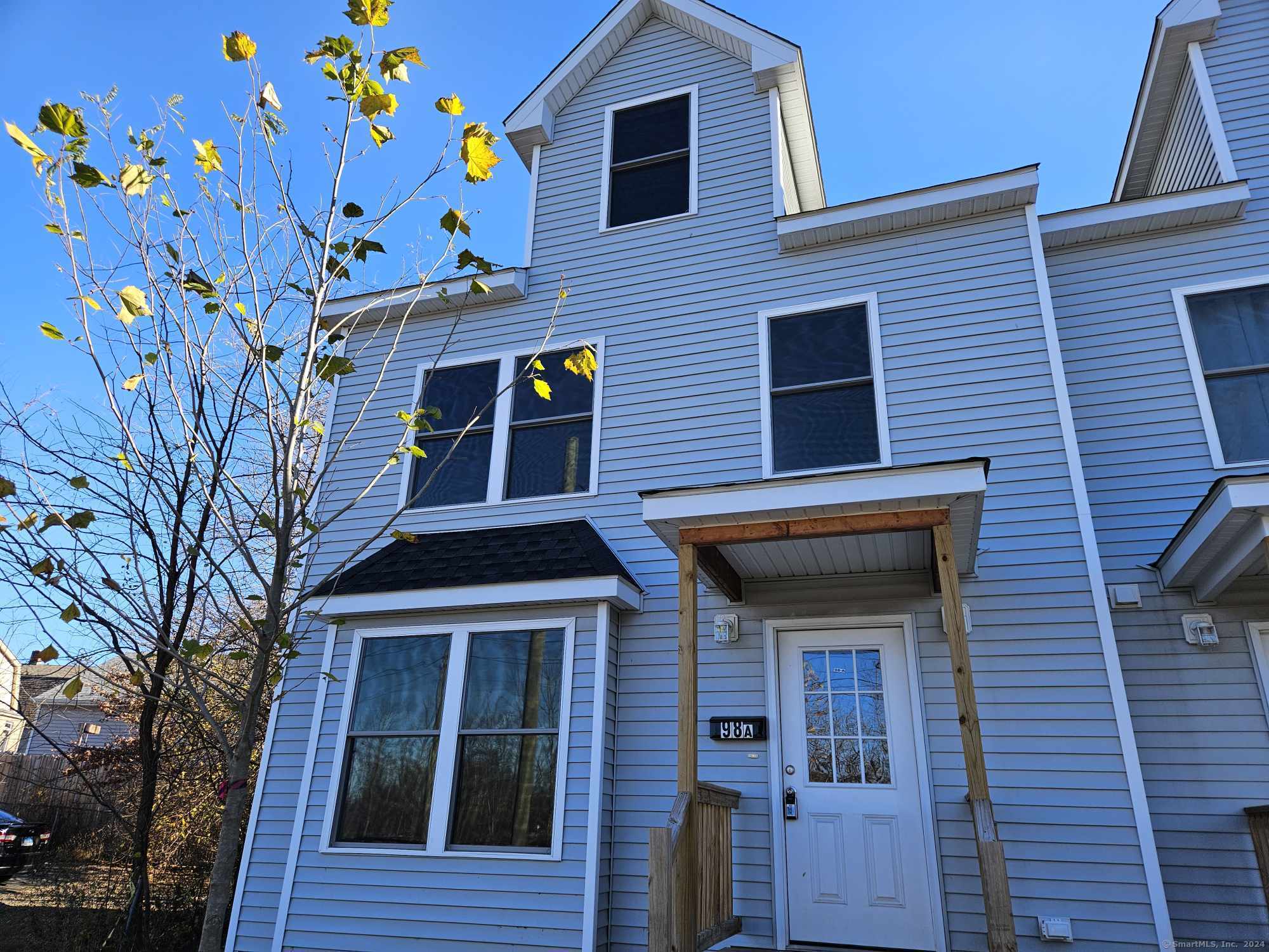 a front view of a house with a tree