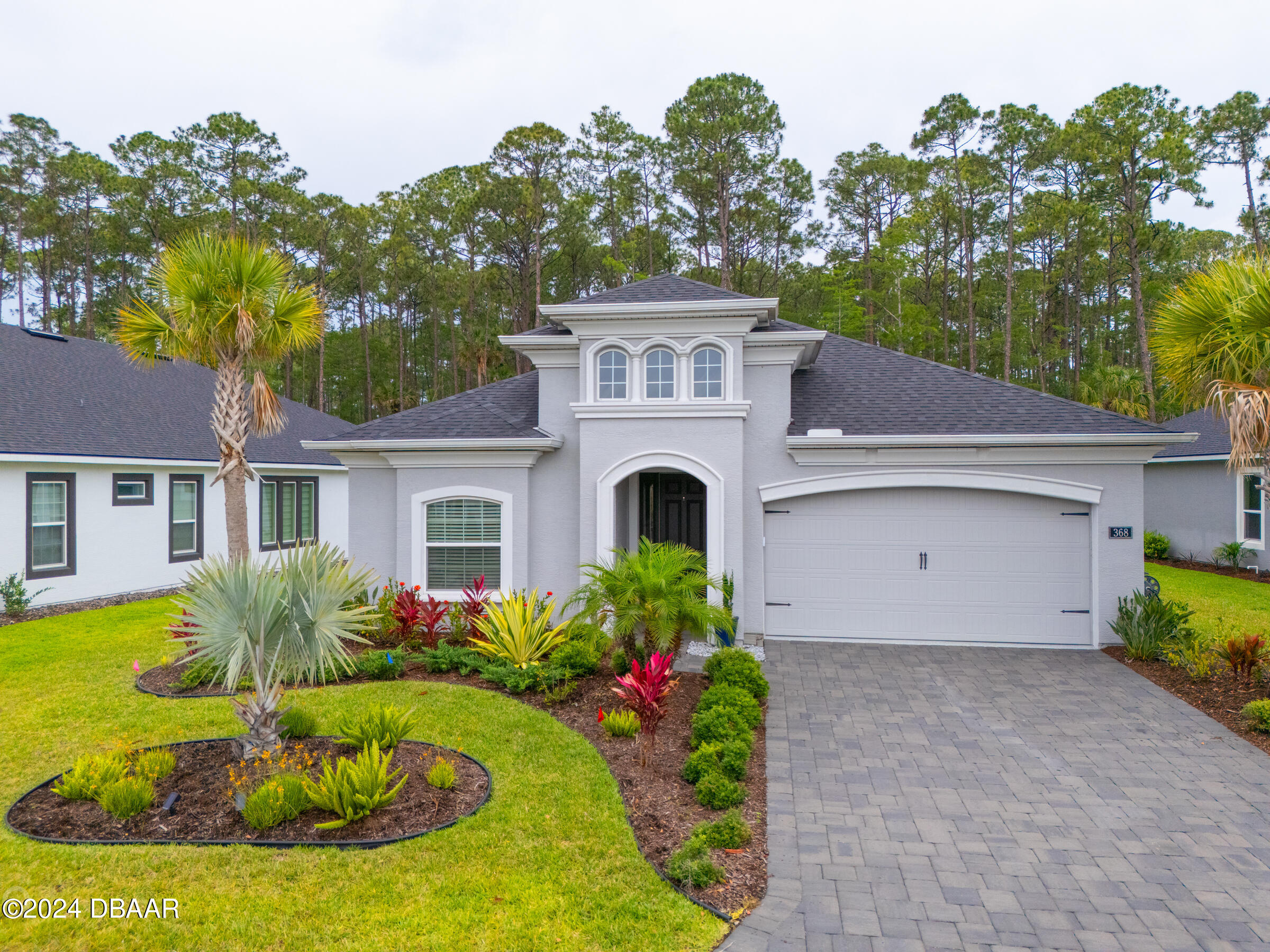 a front view of house with yard and trees in the background