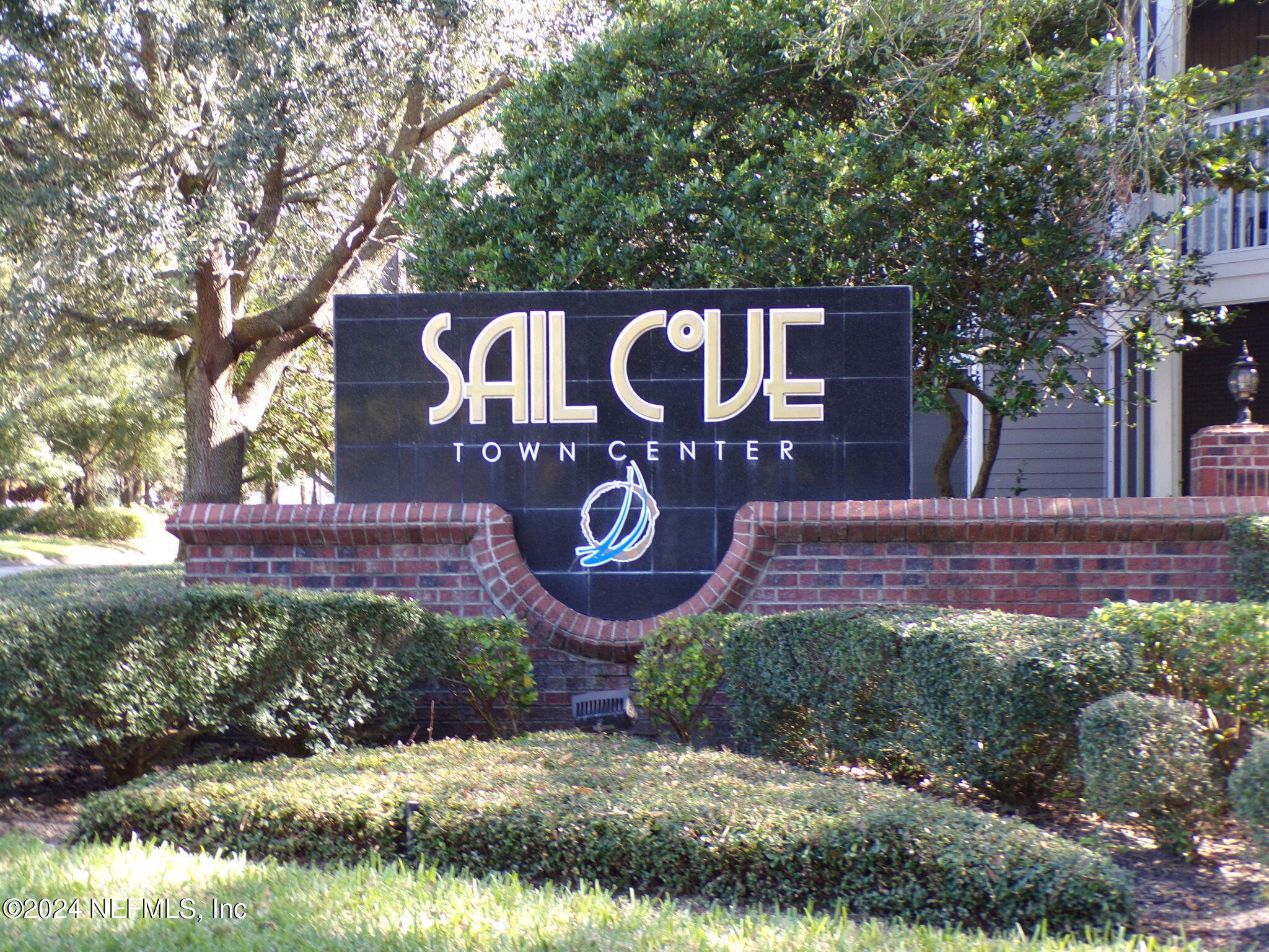 a view of a street sign under a large tree