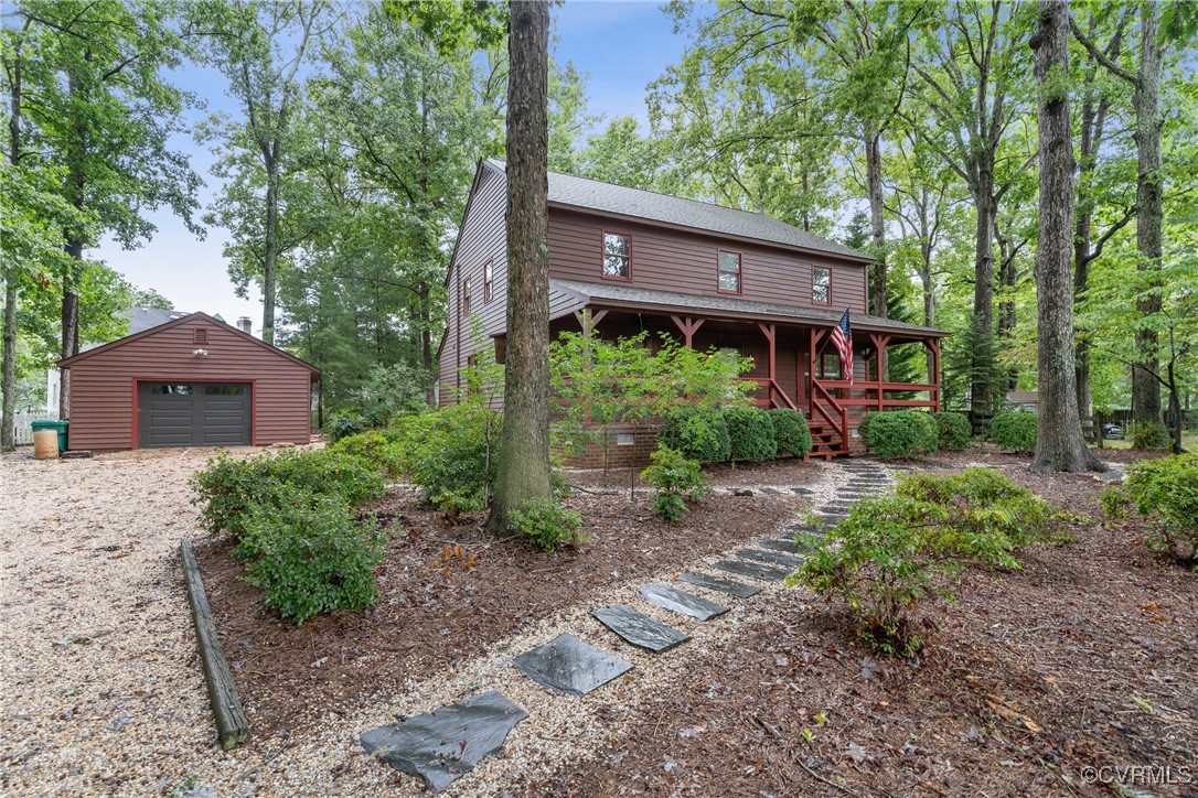 Log-style house featuring an outbuilding and a gar