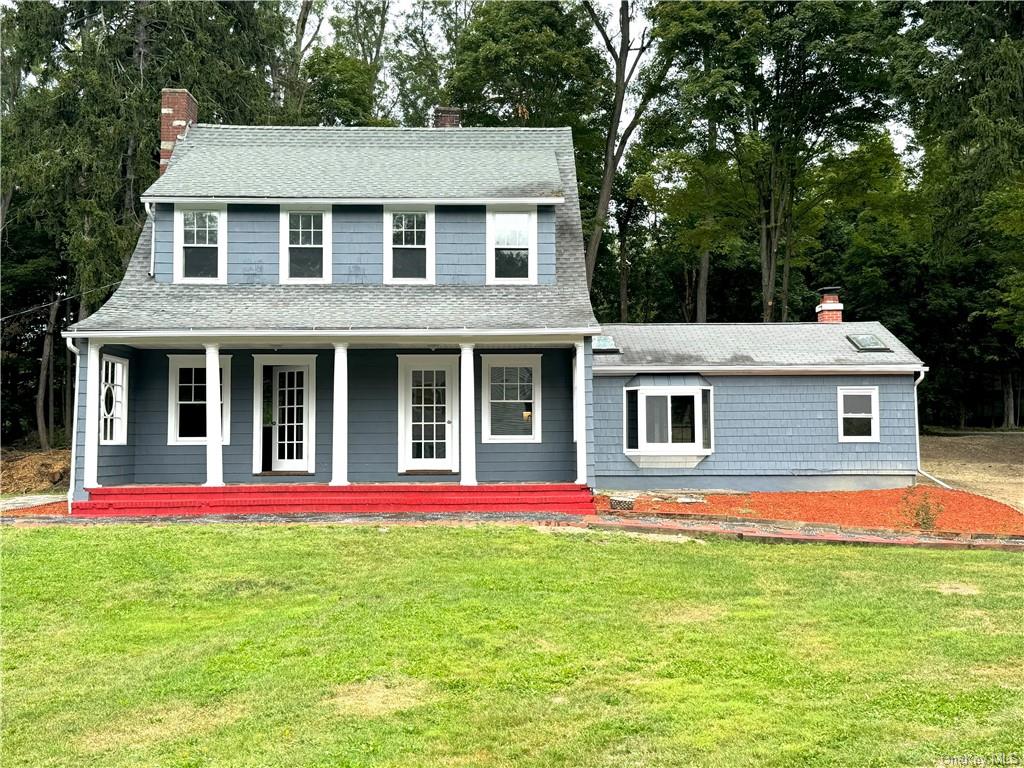 View of front of home featuring a front yard and a porch