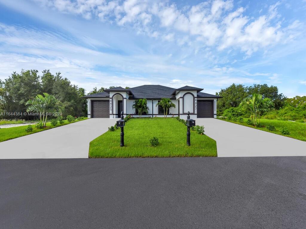 a view of a big house with a big yard and large trees