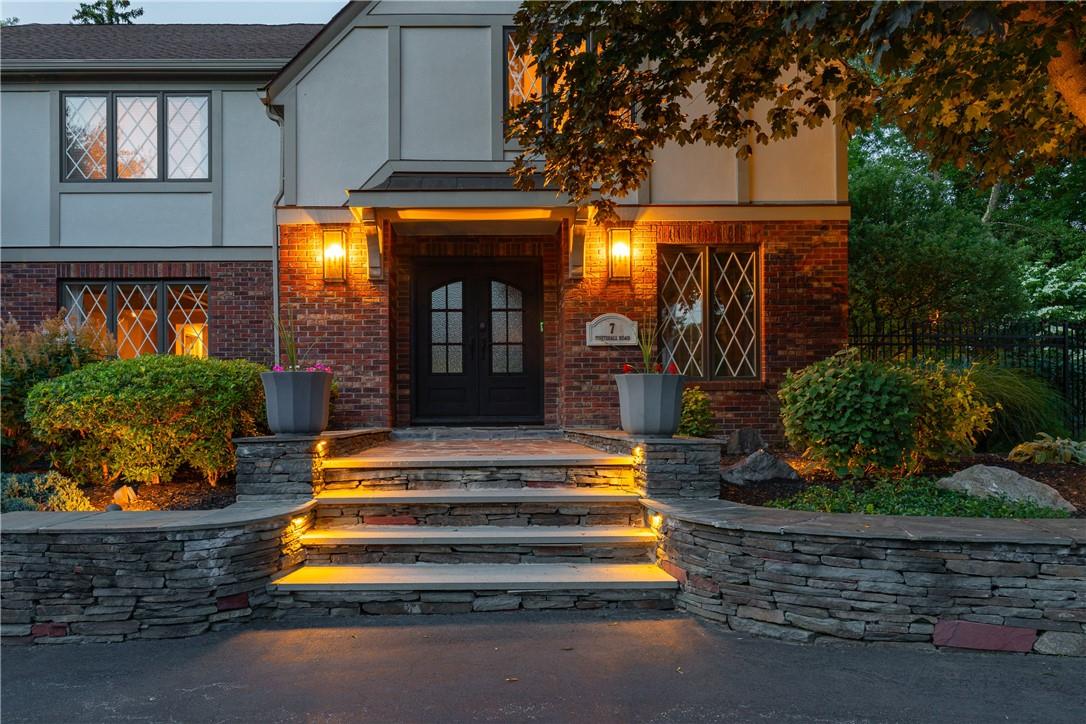 a view of a house with large windows and a fountain