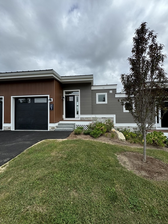 a front view of a house with a yard and garage