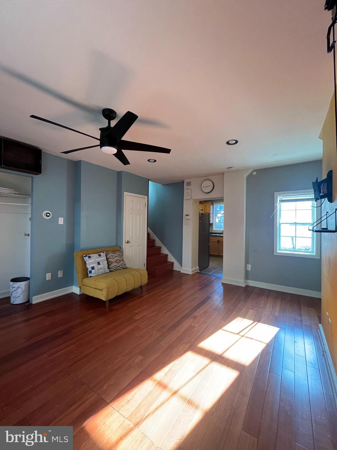 a living room with hard wood floors and a ceiling fan