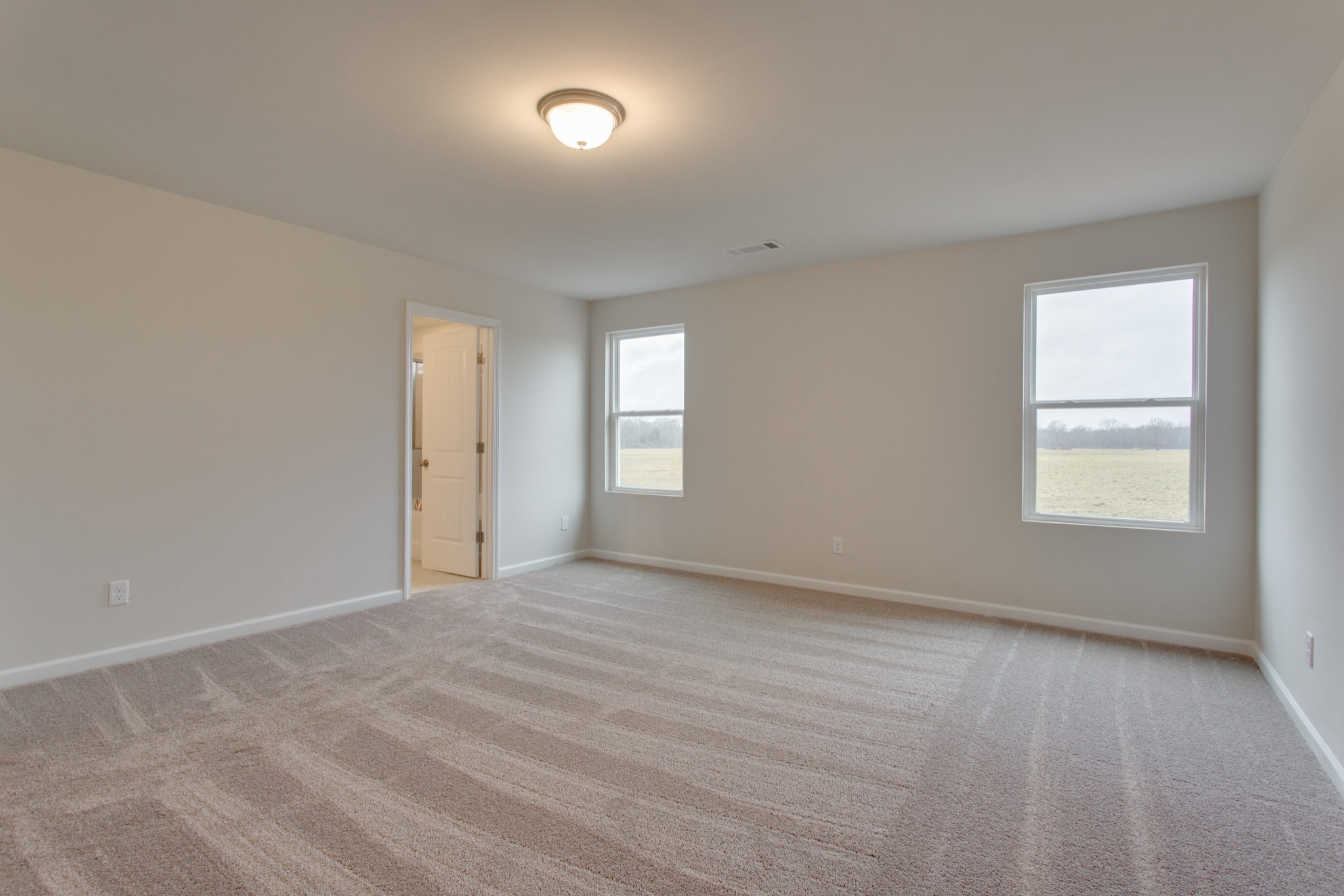 an empty room with windows and closet