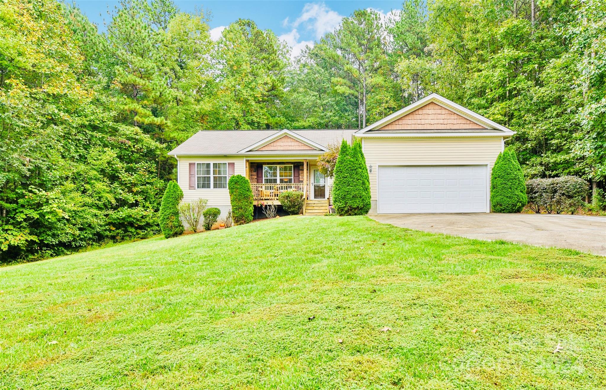 a front view of a house with yard and green space