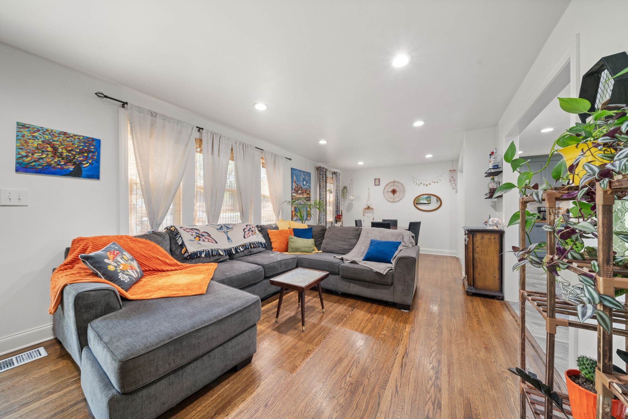 a living room with furniture and a wooden floor