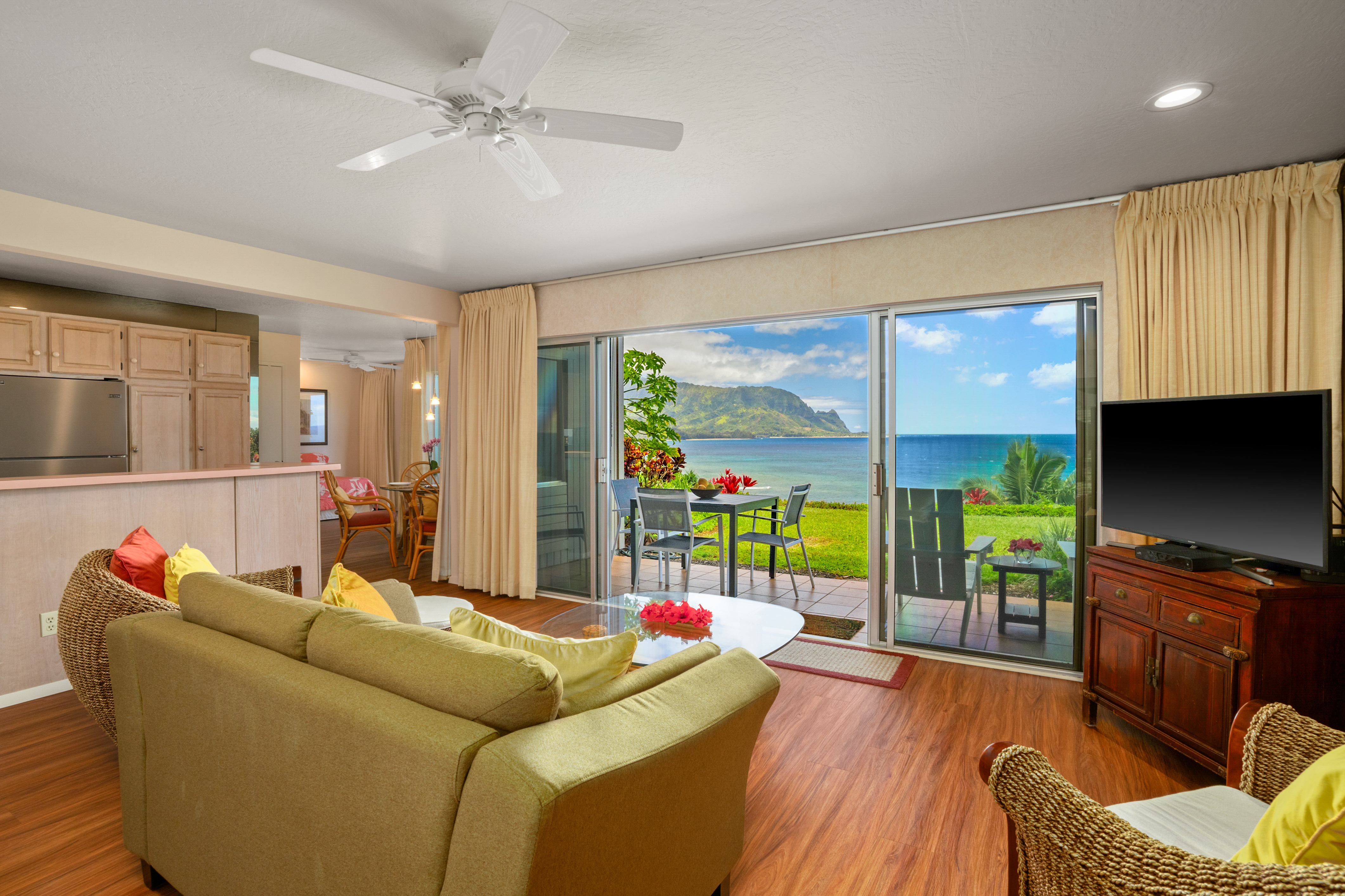 a living room with furniture a flat screen tv and a floor to ceiling window