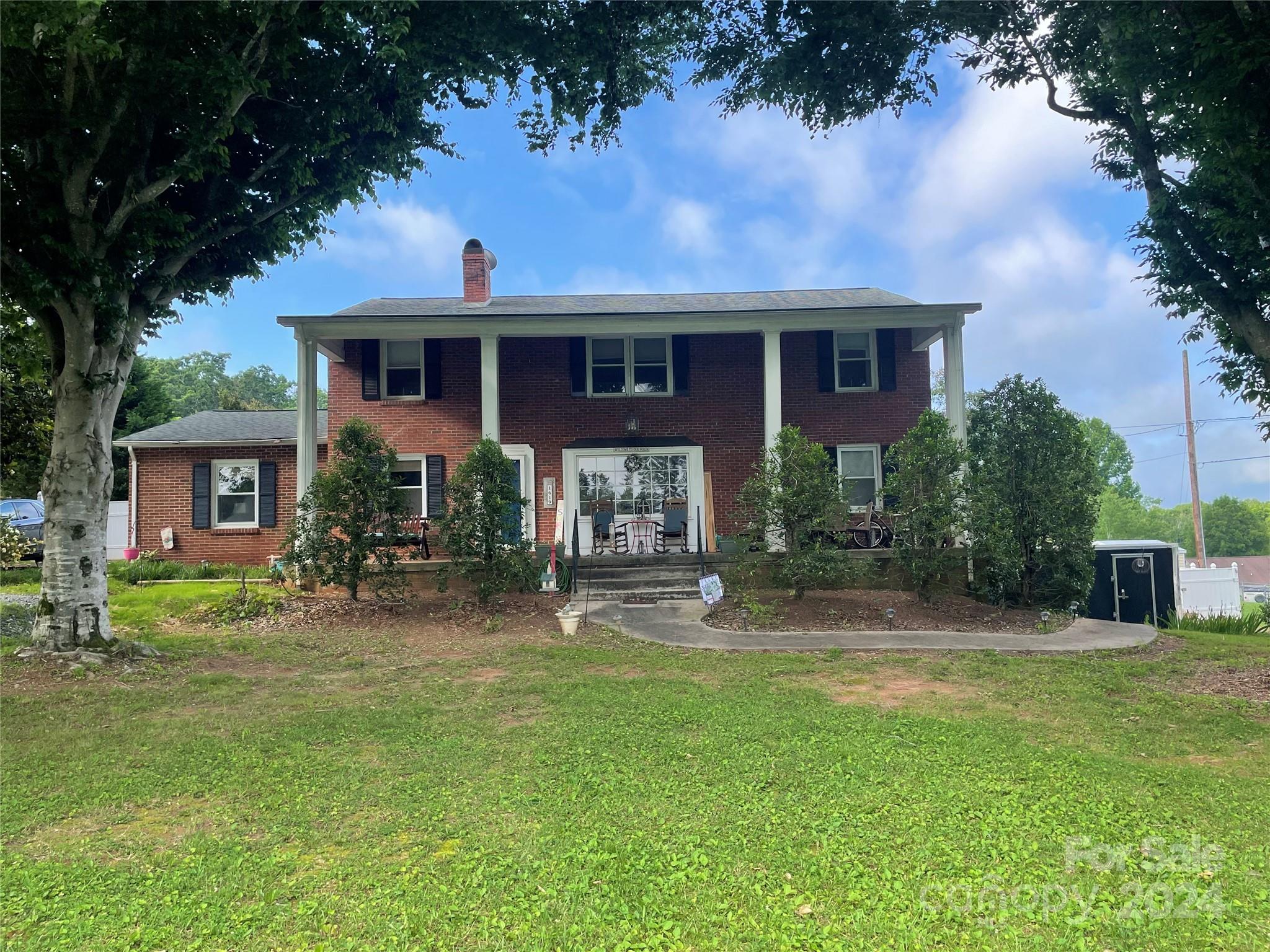 a front view of a house with a yard and trees