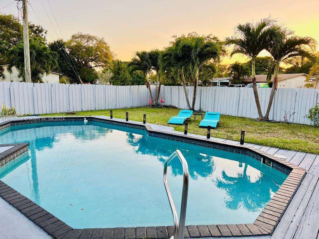 a view of swimming pool with a garden and outdoor seating