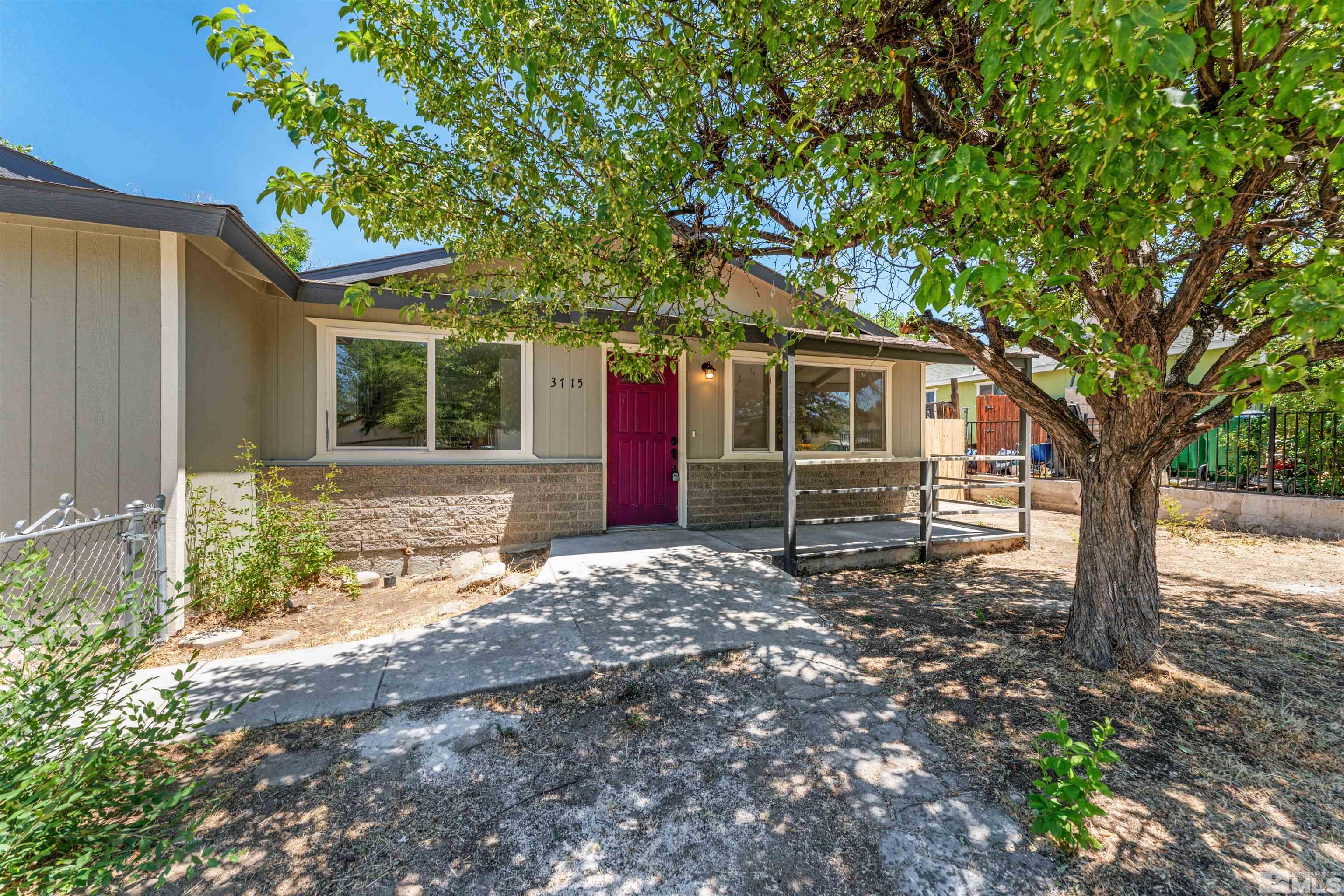 a front view of a house with a tree and garden