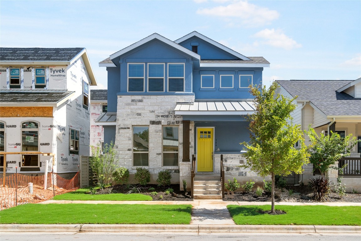 a view of a big house with a yard and plants