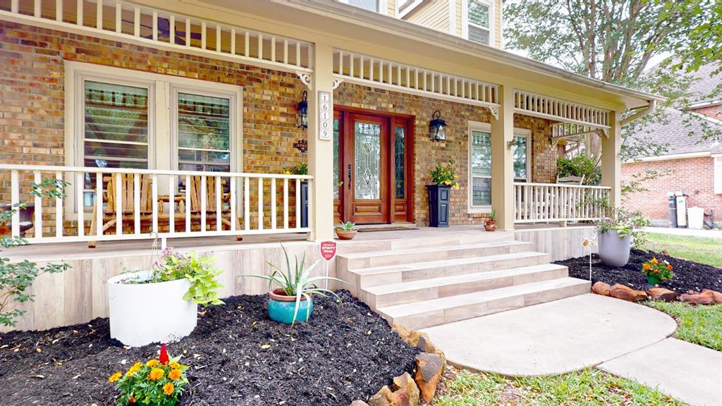 a view of a house with potted plants and a bench in front of house