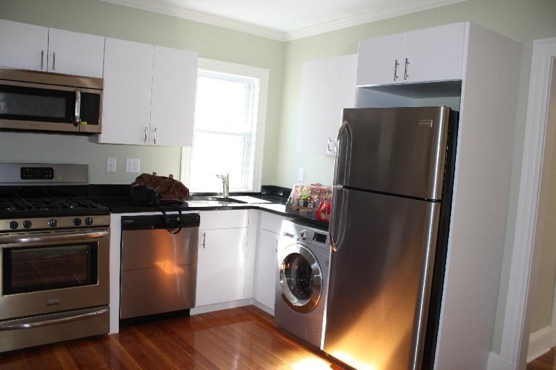 a kitchen with a refrigerator and a stove top oven