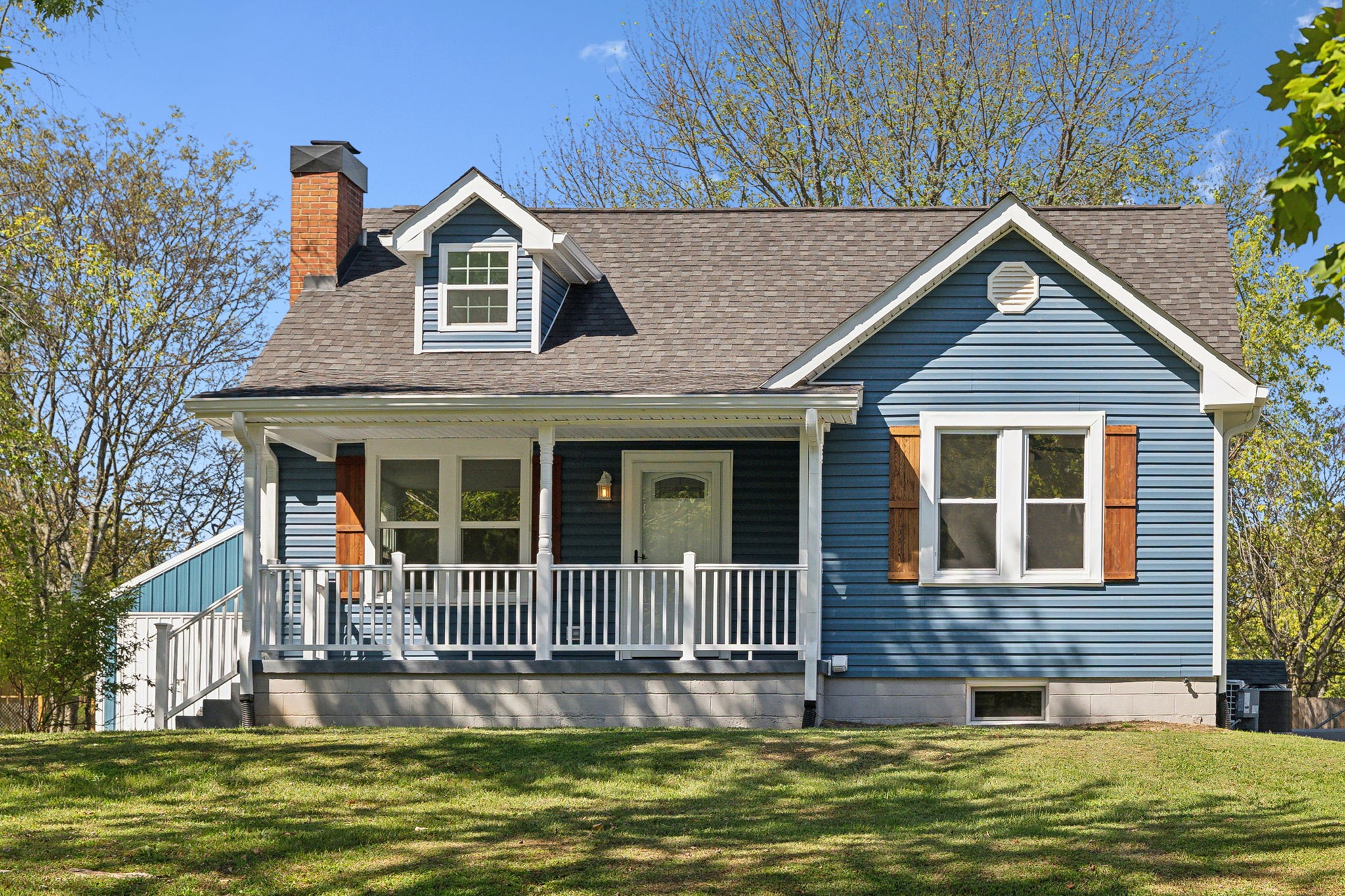 a front view of a house with a garden and plants