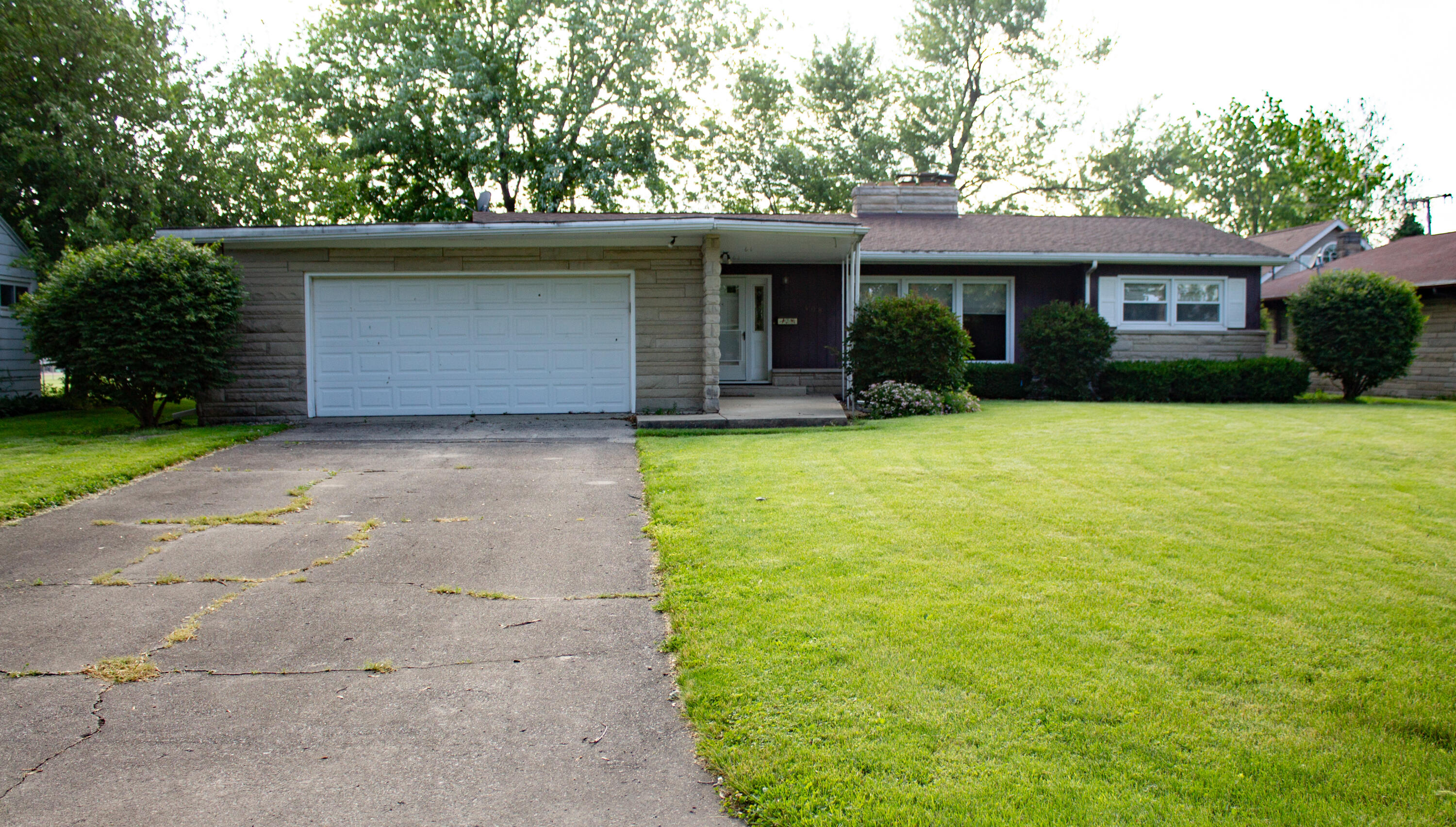 a front view of a house with a garden and yard