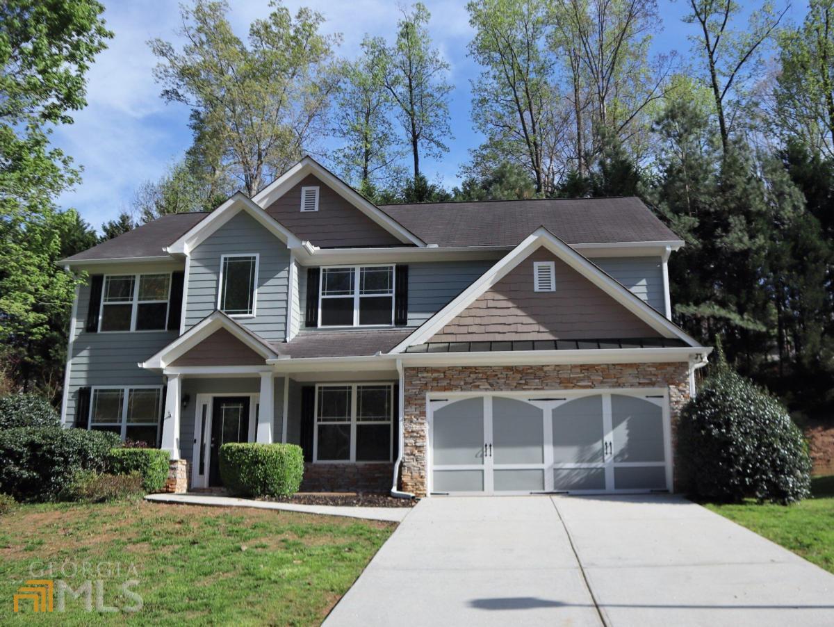 a front view of a house with a yard and trees