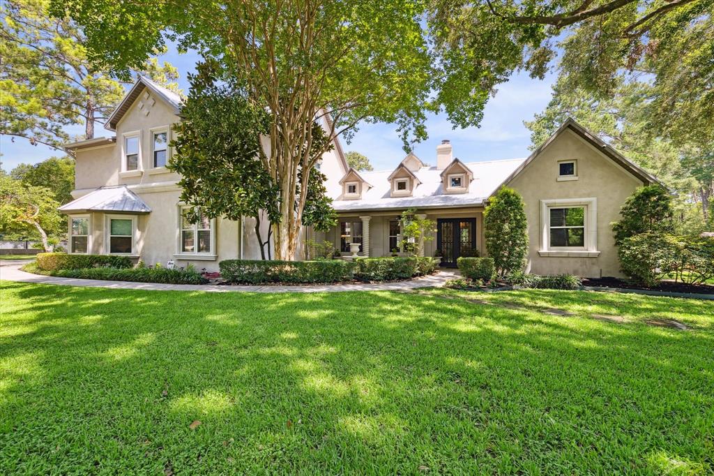 a front view of a house with a yard and trees