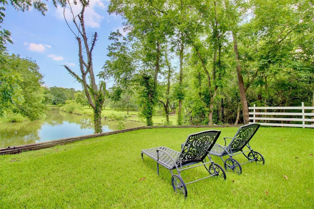 a view of a swimming pool with lawn chairs and a yard