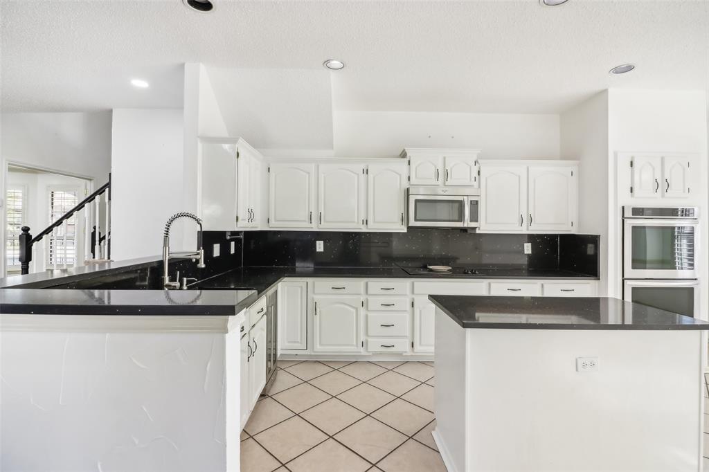 a kitchen with stainless steel appliances granite countertop a sink stove and cabinets