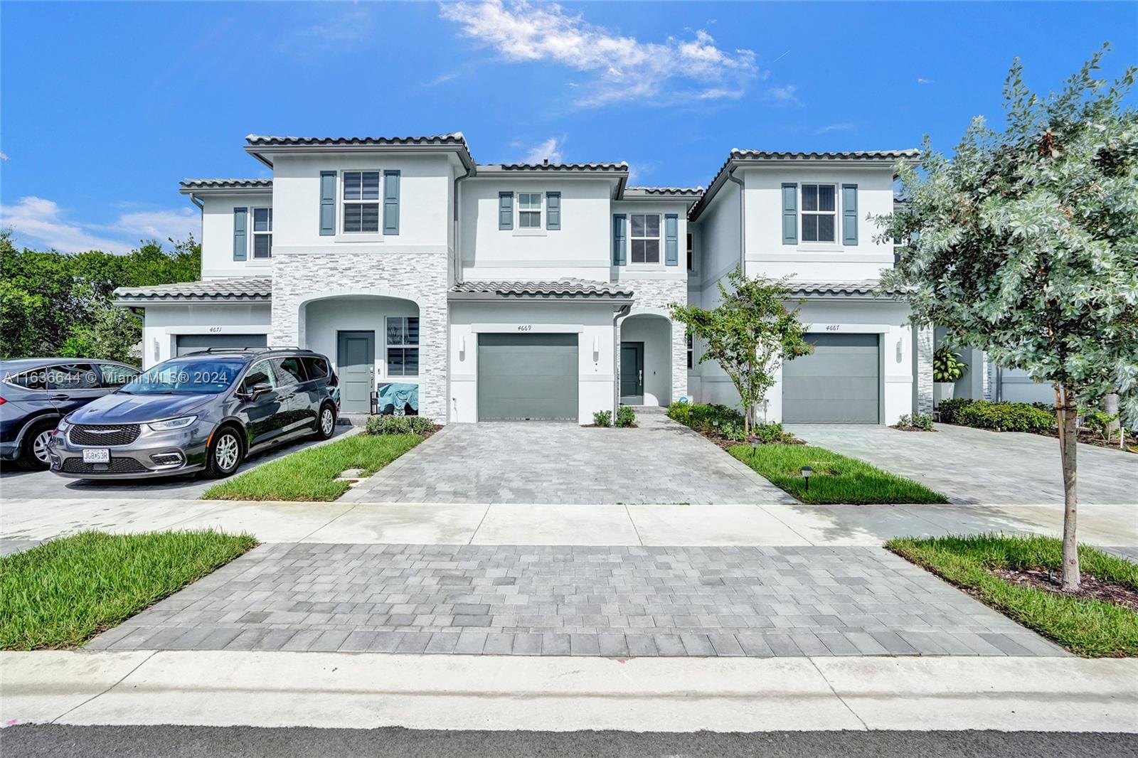 a front view of a house with garden and parking