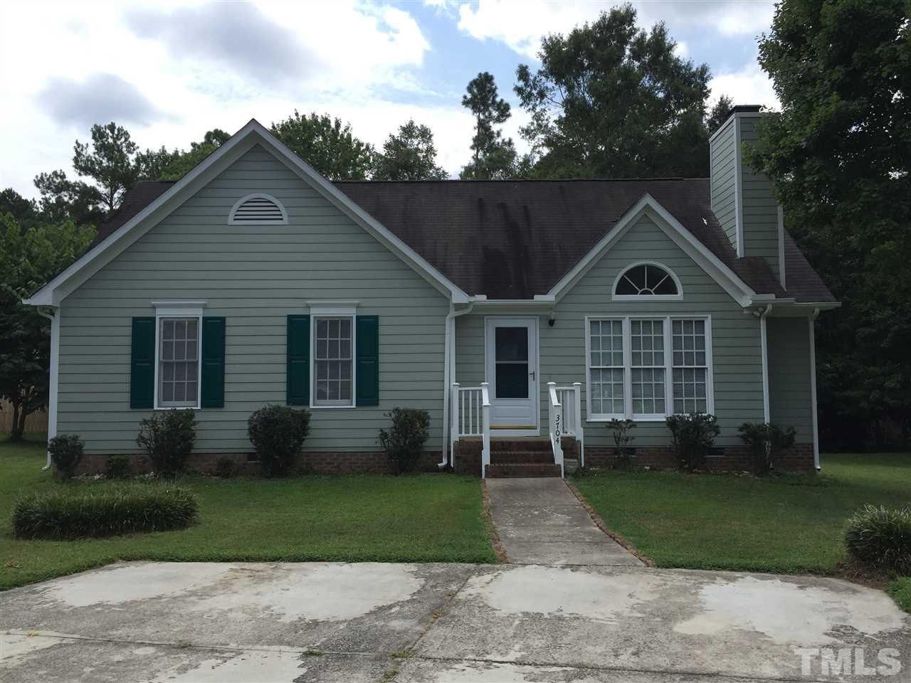 a front view of a house with a garden and plants