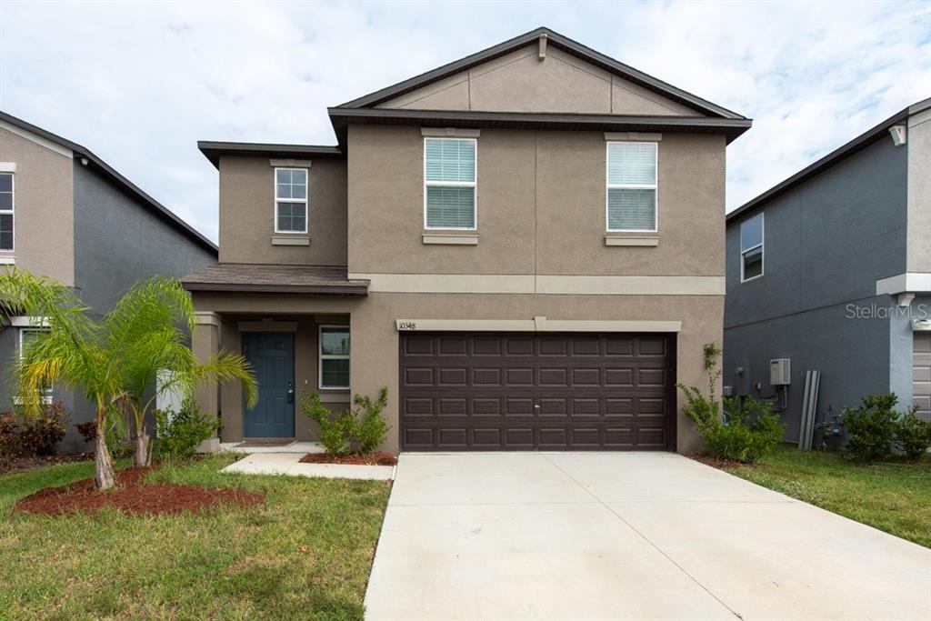 a front view of a house with a yard and garage