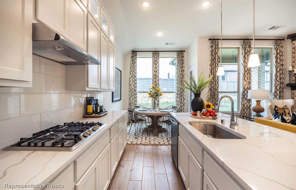 a kitchen with sink a stove and a refrigerator