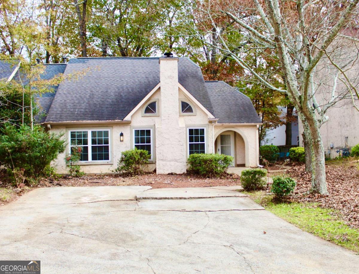 a front view of a house with a yard and trees