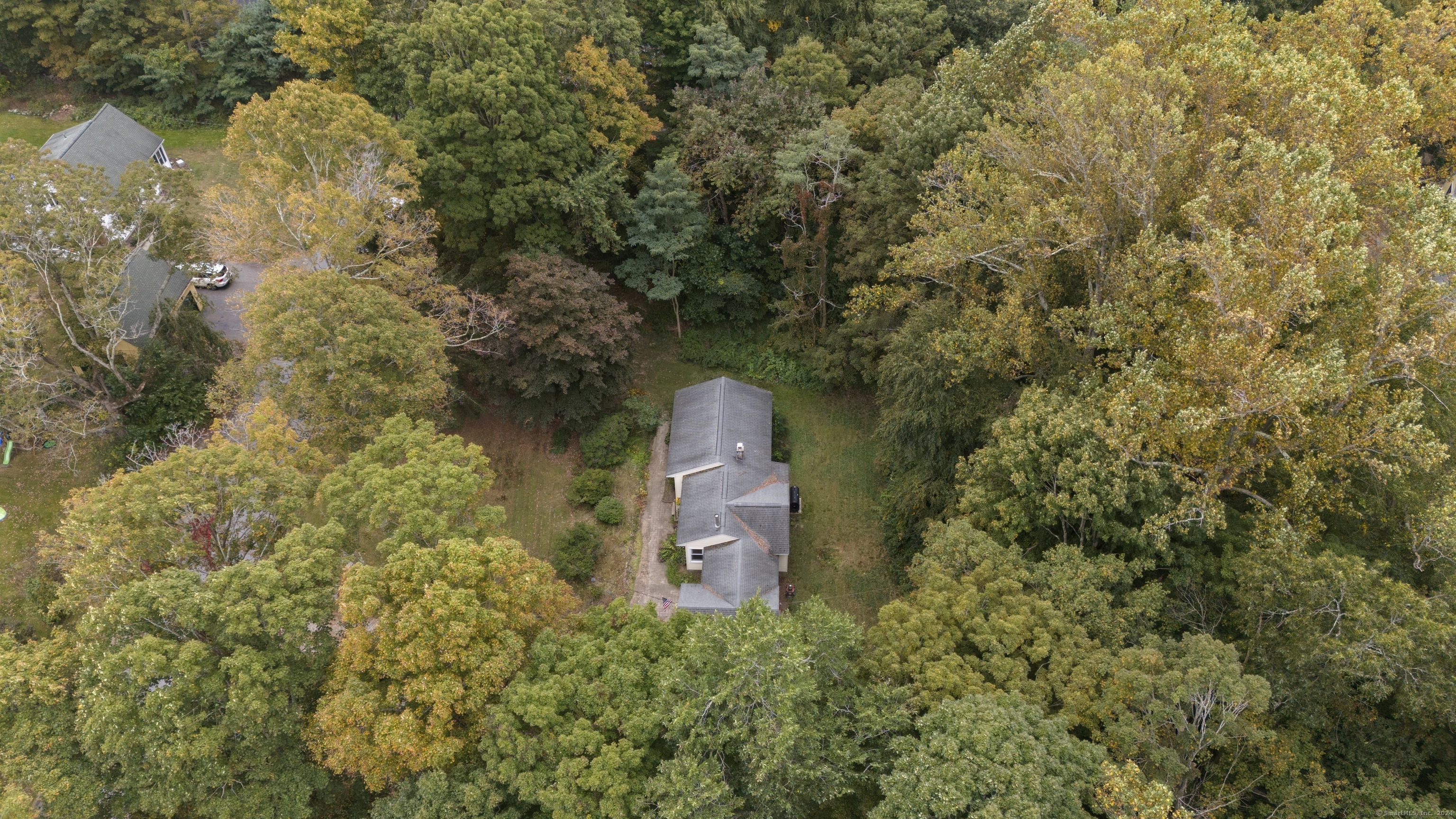 a aerial view of a house with a yard and large tree