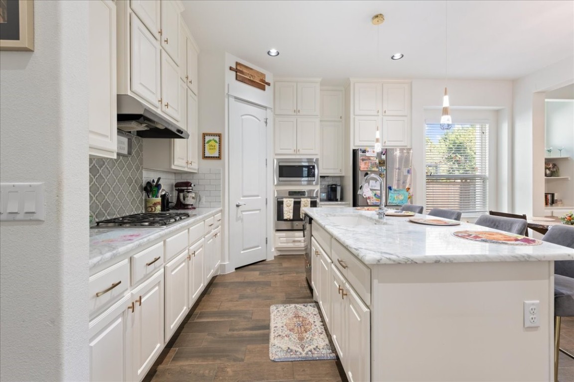 a kitchen with stainless steel appliances granite countertop a sink and cabinets