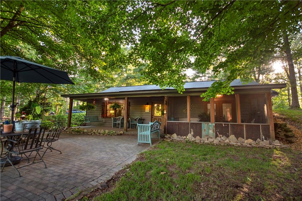 a view of a backyard with table and chairs under an umbrella with wooden fence