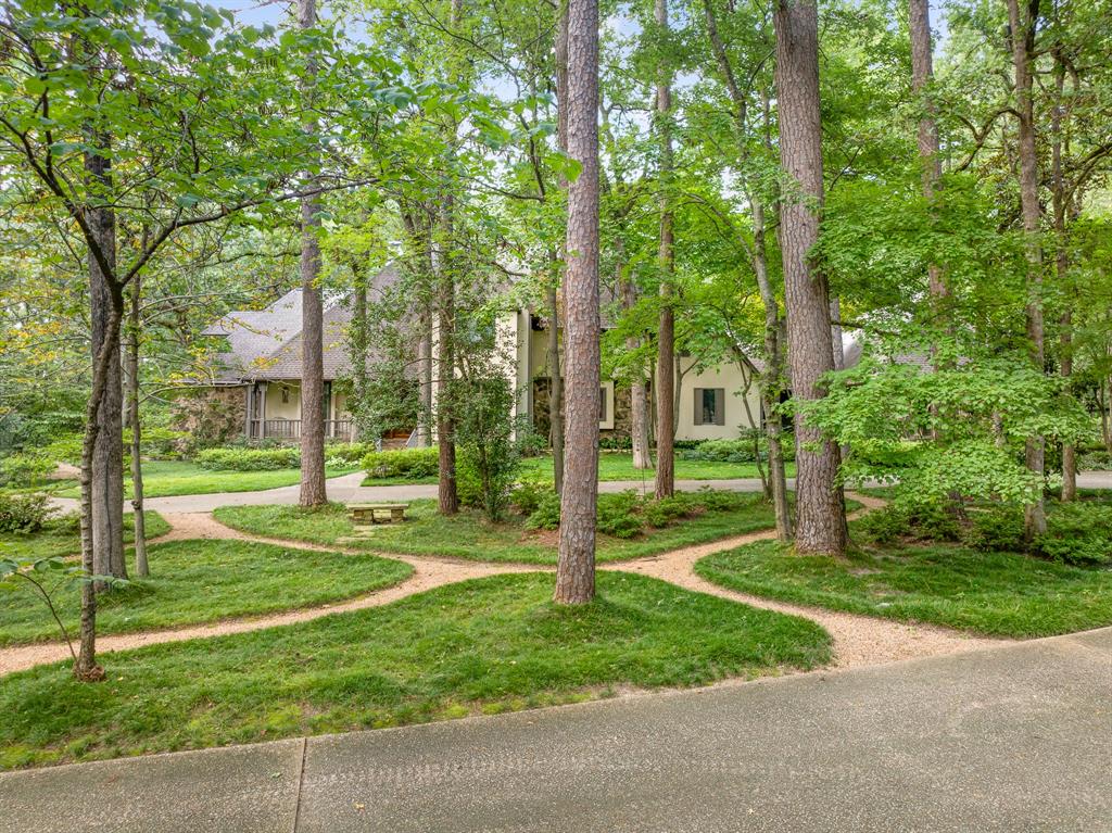 a view of a house with a big yard and large trees