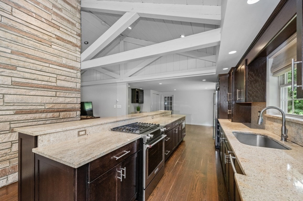 a kitchen with stainless steel appliances granite countertop a sink stove and cabinets