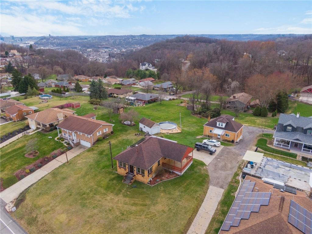 an aerial view of a house with garden space and mountain view in back