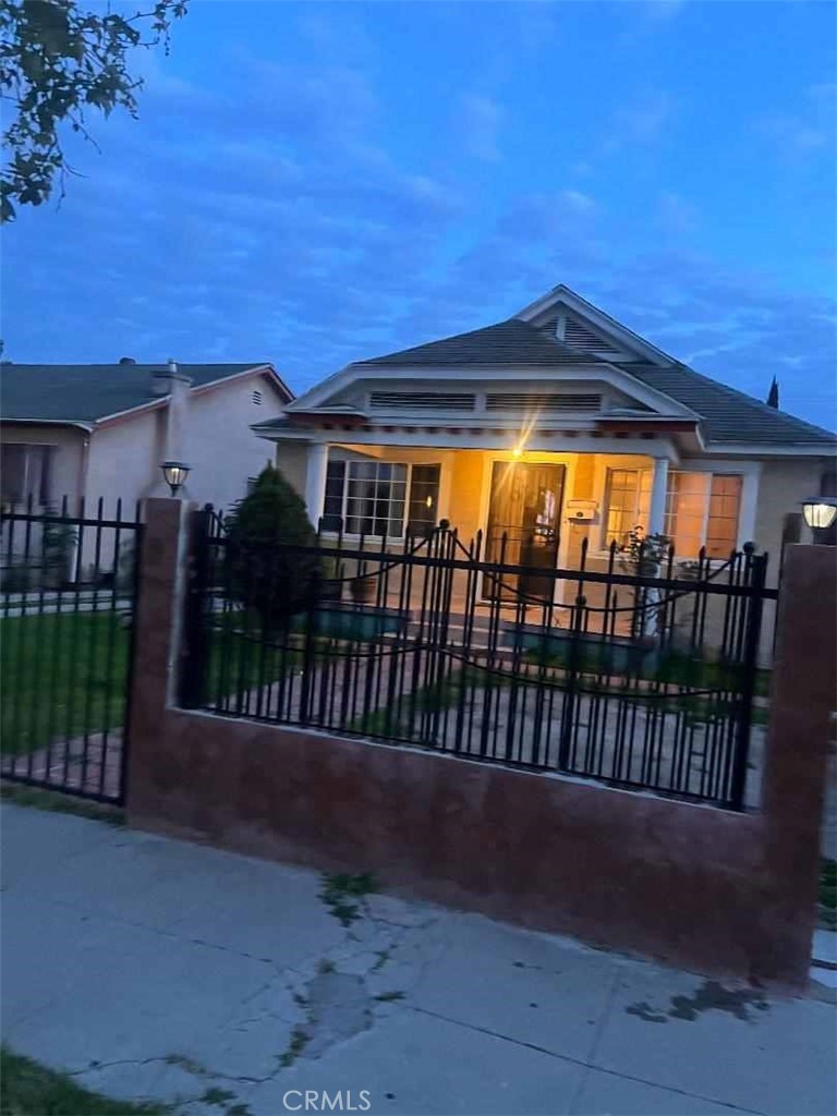 a view of a house with a small yard and wooden fence