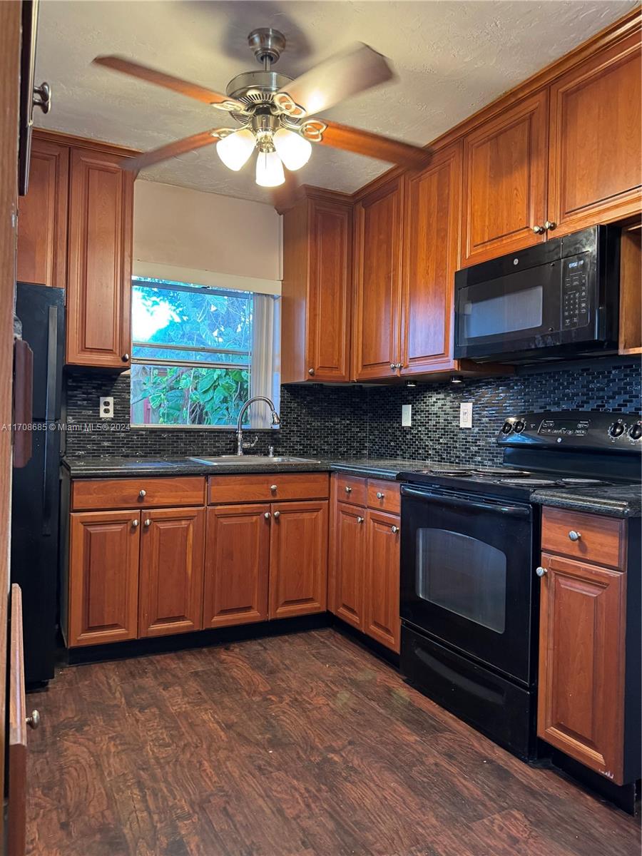 a kitchen with stainless steel appliances granite countertop wooden cabinets a stove a sink and dishwasher